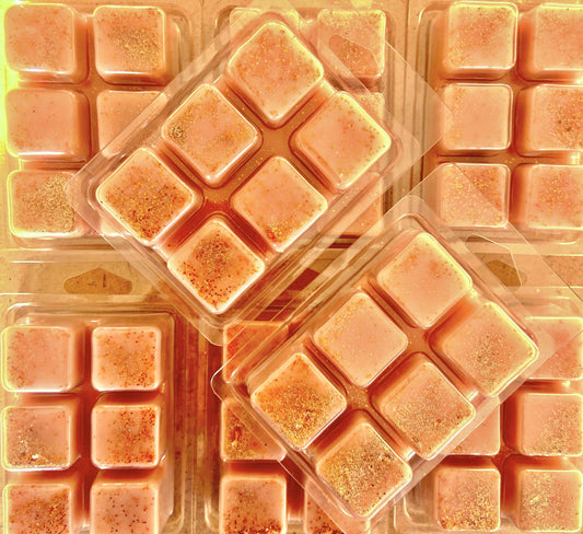 Close-up of multiple clamshell packages containing soy wax melts, some with a sparkly biodegradable glitter topping, in a delightful Ginger and Cherry Wax Melt scent from The Soap Gal x.